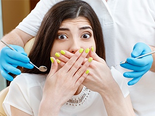 woman with green nails covering mouth