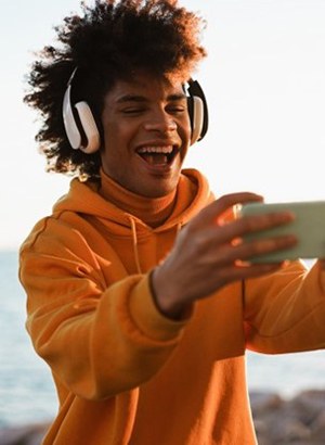 a young person smiling and taking a selfie on a lake