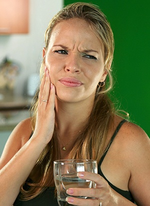 woman holding water with jaw pain