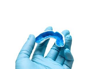 dentist holding dental impressions for a customized mouthguard